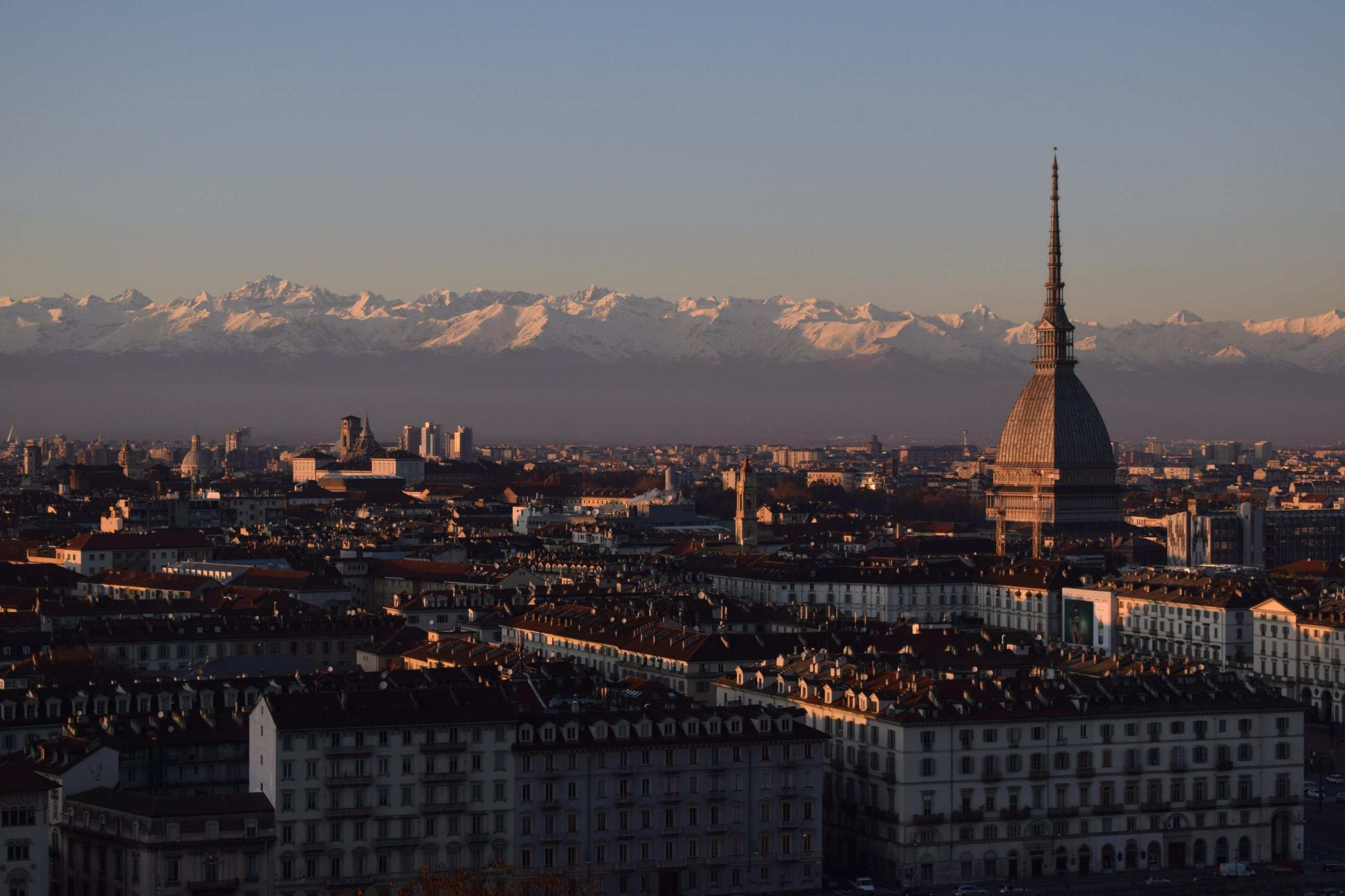 La Mole Antonelliana sopra i tetti di Torino, con le Alpi innevate sullo sfondo